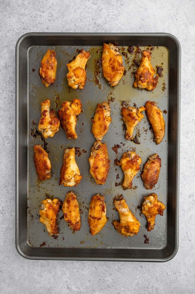 Baked Crispy Chicken Wings on a baking sheet on a grey background. 