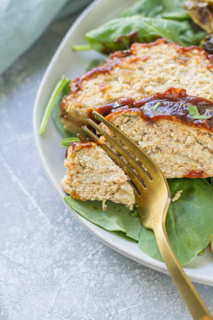 BBQ Chicken Meatloaf with a gold fork taking a bite out of it