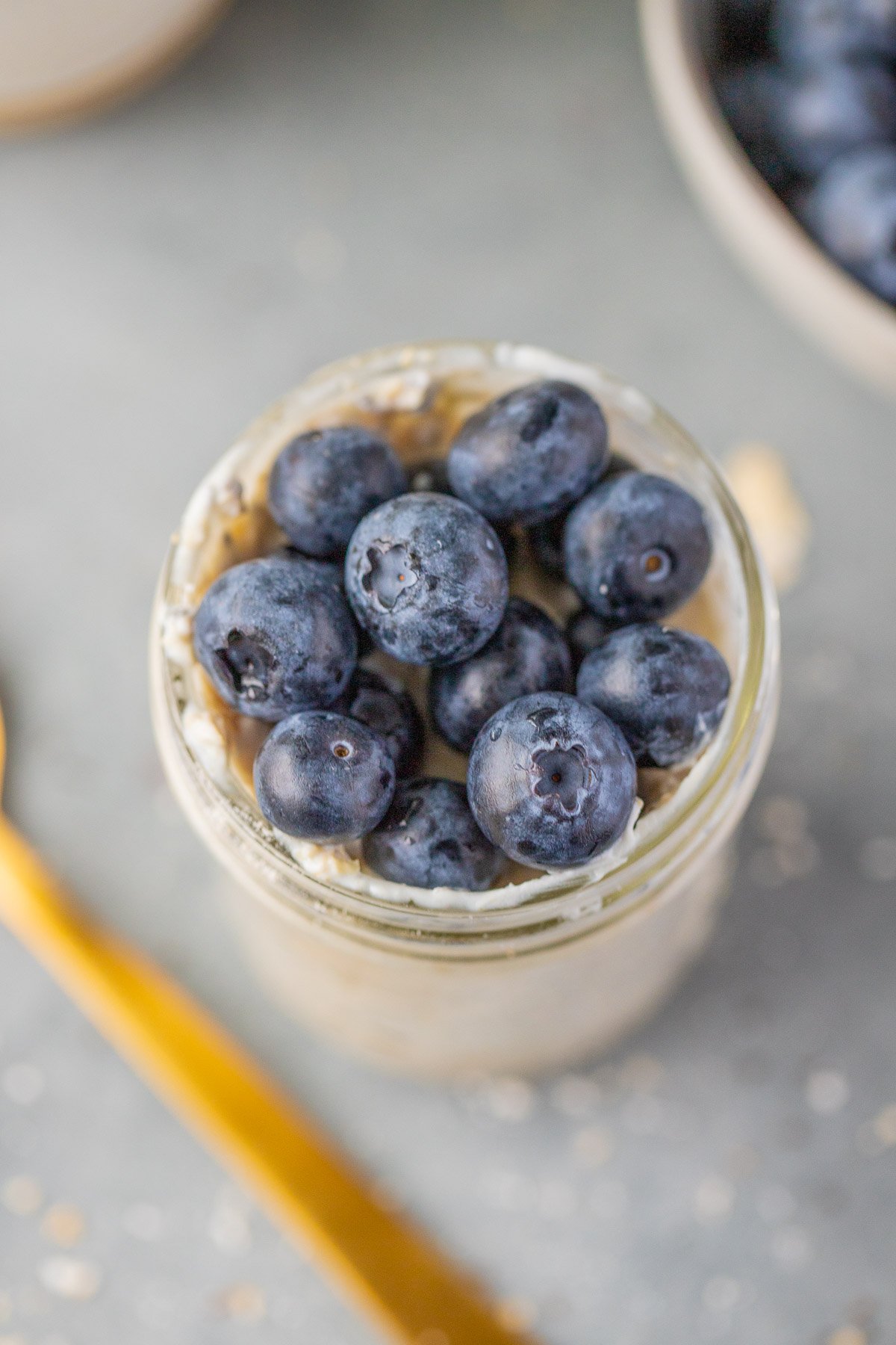 Blueberry Overnight Oats in a mason jar on a grey background