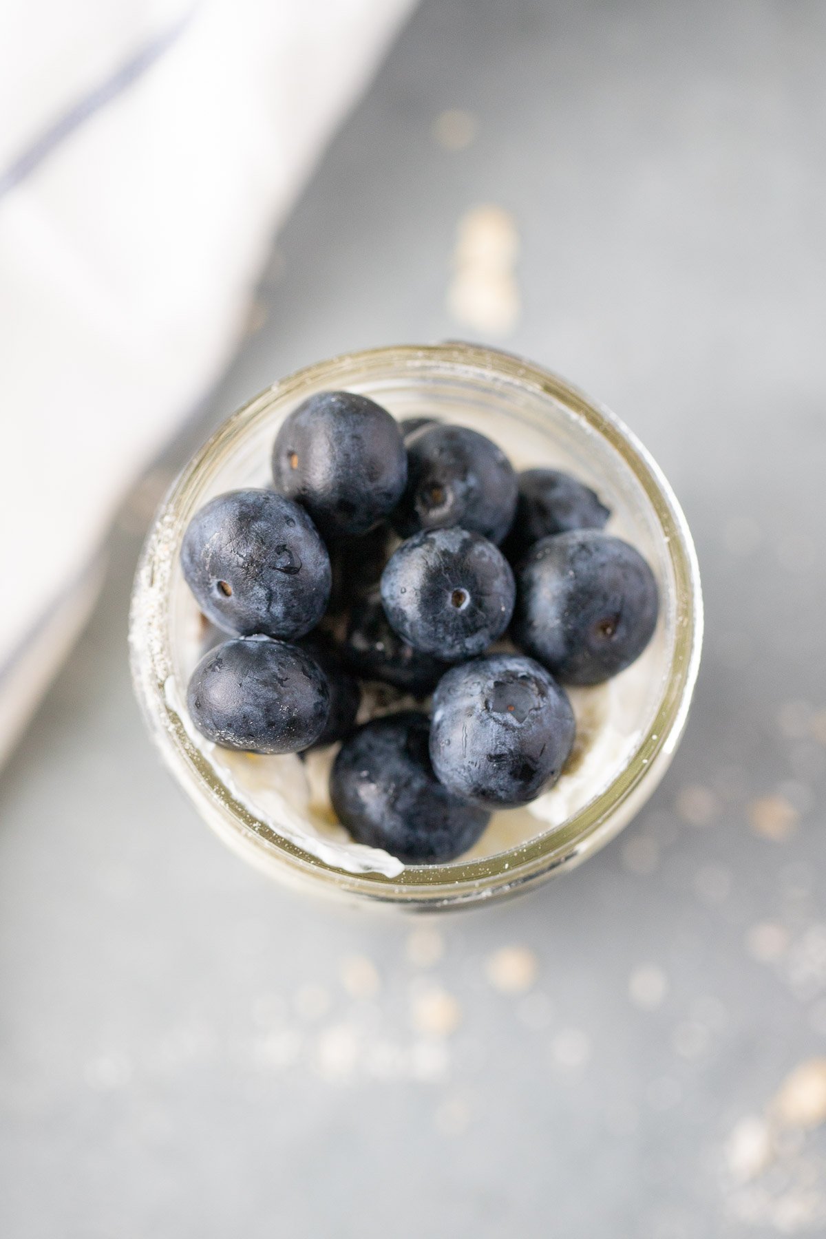 An overhead image of overnight blueberry oats on top of a grey background
