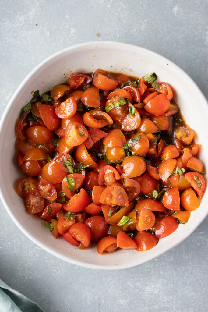 Homemade bruschetta in a white bowl on a grey background