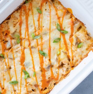 An overhead image of Buffalo Chicken Casserole in a white dish on a grey background