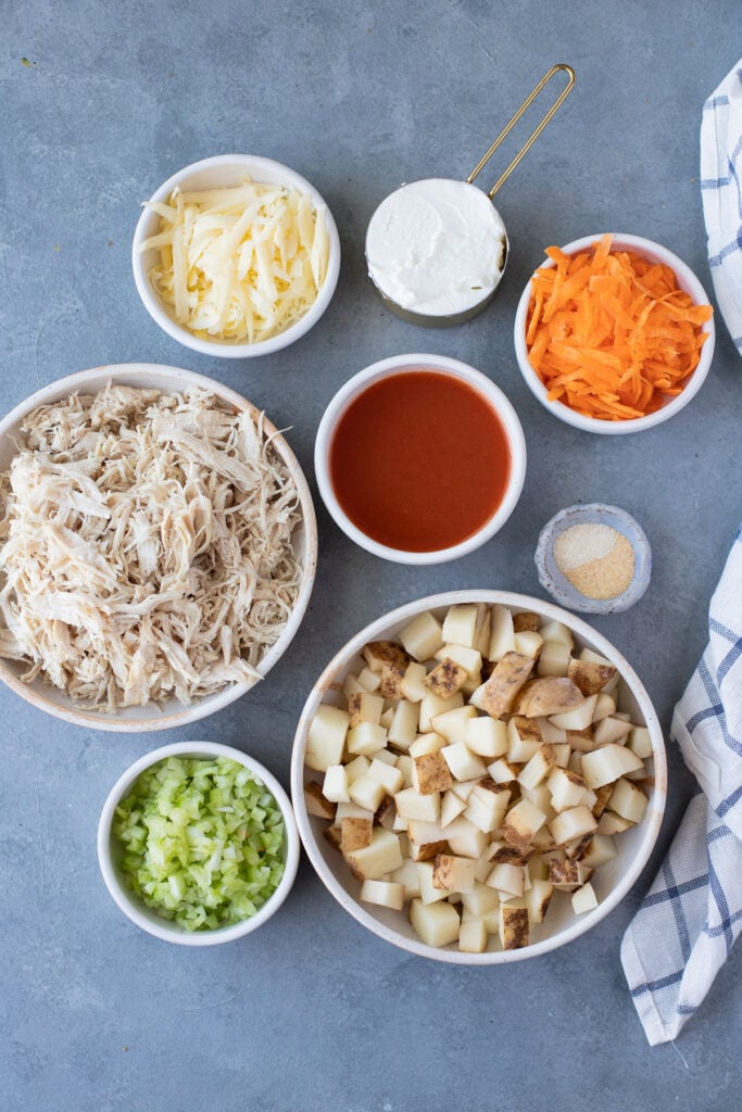 Ingredients for Buffalo Chicken Casserole: olive oil, shredded chicken, potatoes, buffalo sauce, celery, carrots, garlic powder, onion powder, greek yogurt, cheddar cheese