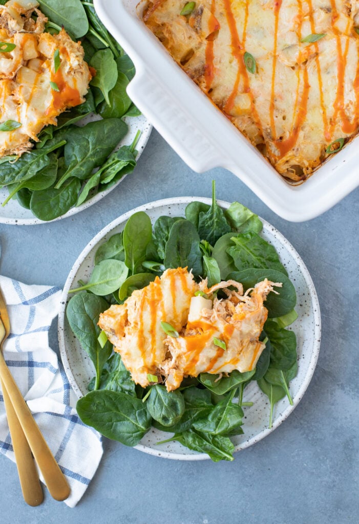 an overhead image of Buffalo Chicken Casserole on a bed of spinach on a white dish