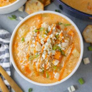 A close up of Buffalo Chicken Soup in a white bowl on a grey background