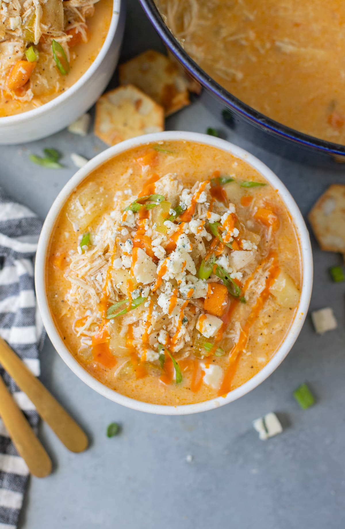 A close up of Buffalo Chicken Soup in a white bowl on a grey background