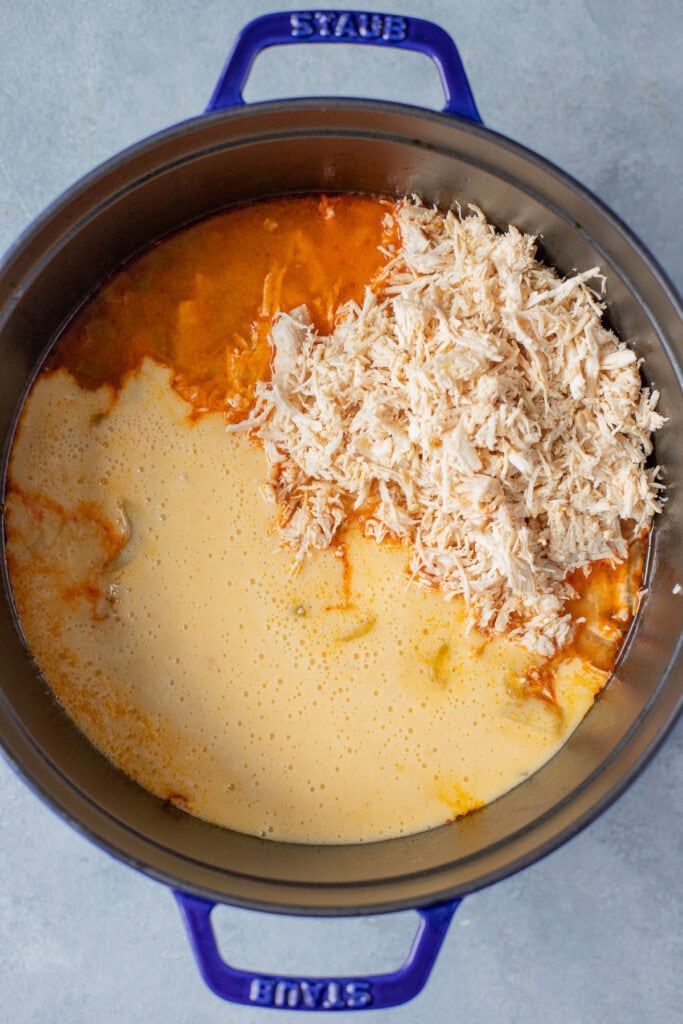 Blender mixture added to pot of ingredients for buffalo chicken soup