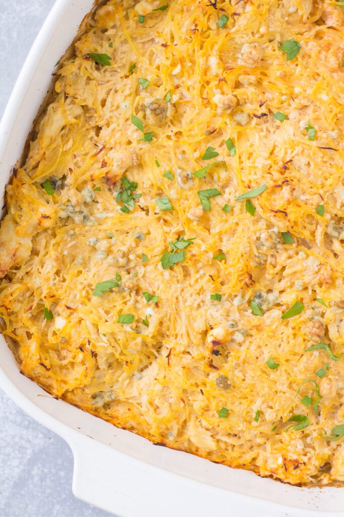 An overhead shot of buffalo chicken spaghetti squash casserole in a white baking dish.