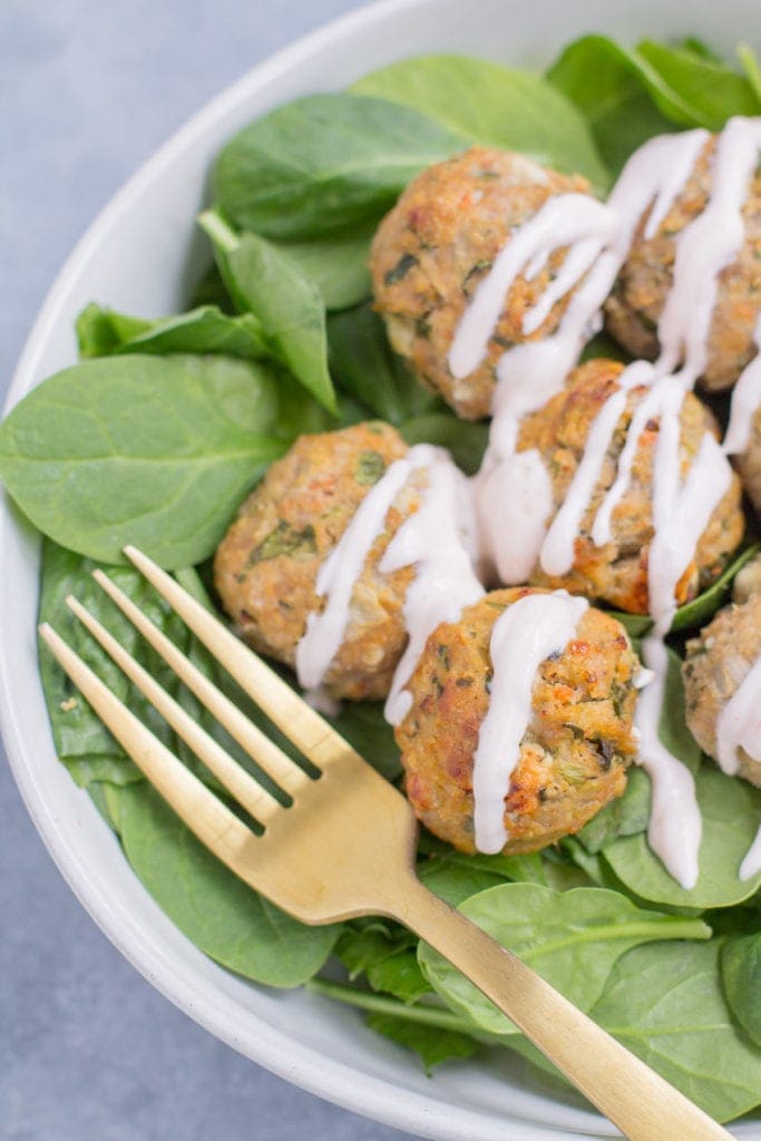 A white bowl with a gold fork taking a bite out of healthy buffalo turkey meatballs.