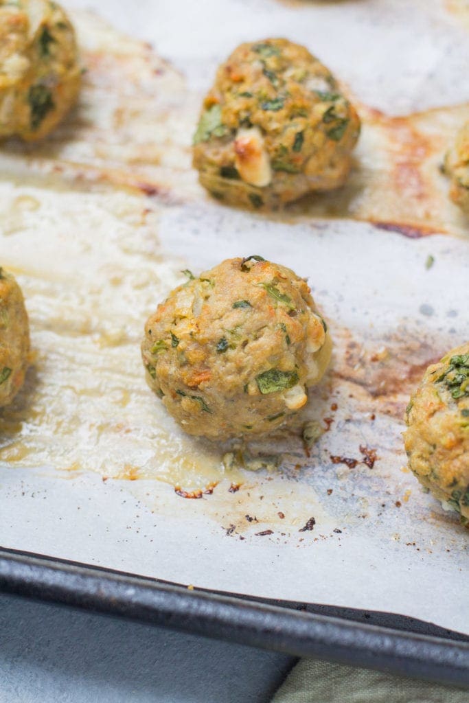 Buffalo Turkey Meatballs out of the oven on a parchment lined baking sheet