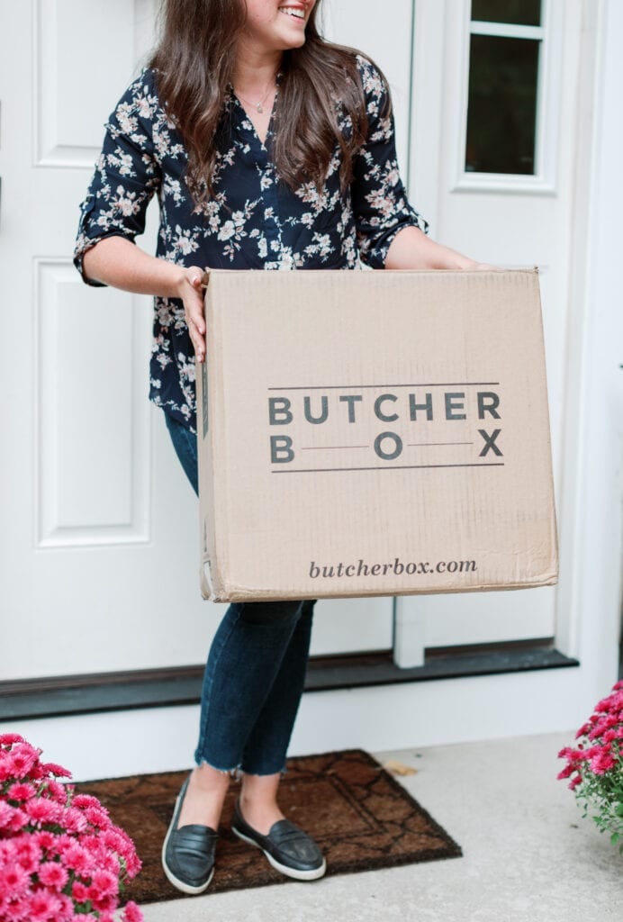 A close up of a girl picking up butcherbox on her front stoop. What comes in a ButcherBox