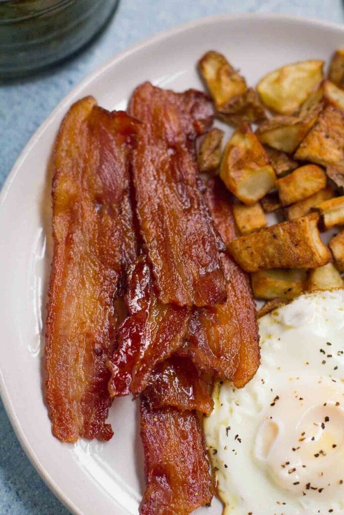 ButcherBox Bacon on a plate with eggs and potatoes