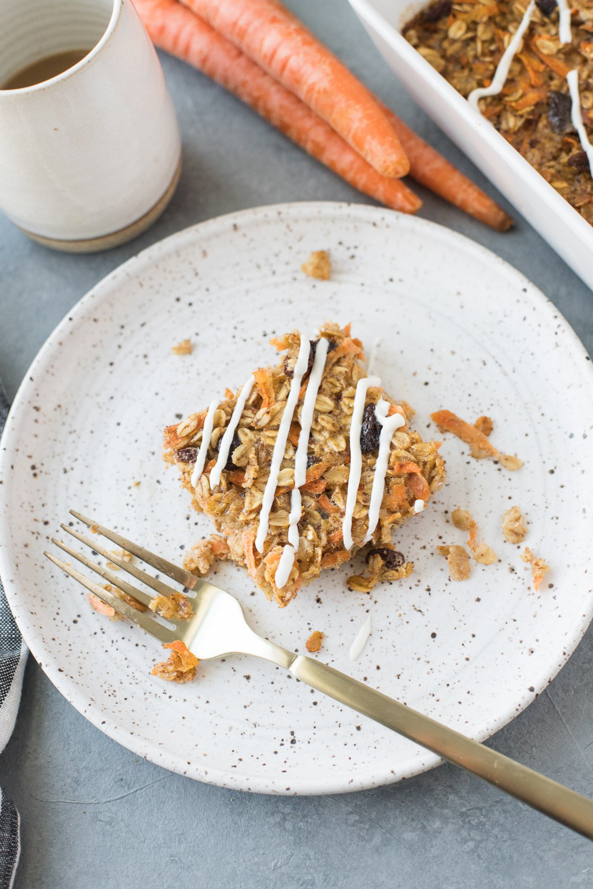 Carrot Cake Baked Oatmeal on a white speckled plate with a gold fork