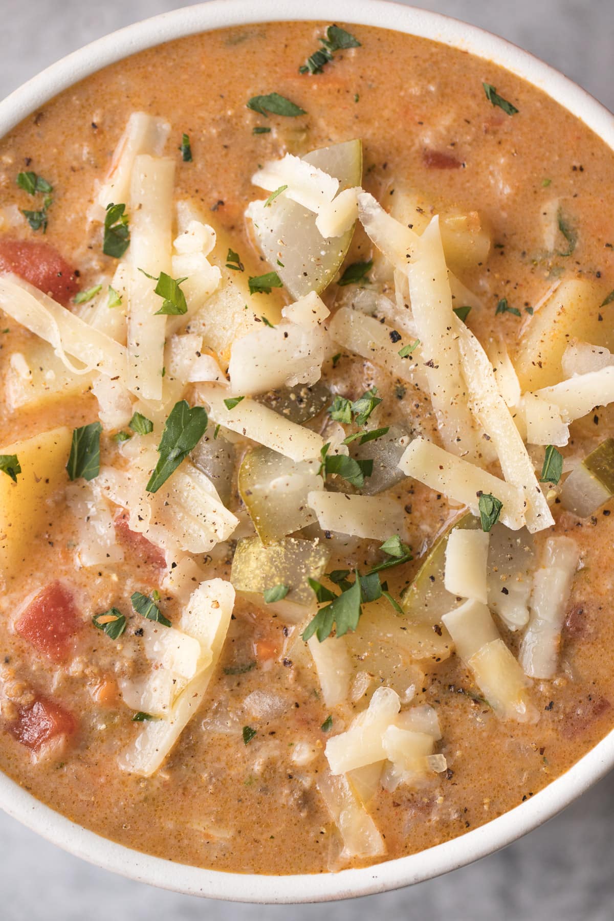 A close up of Cheeseburger Soup in a white soup bowl
