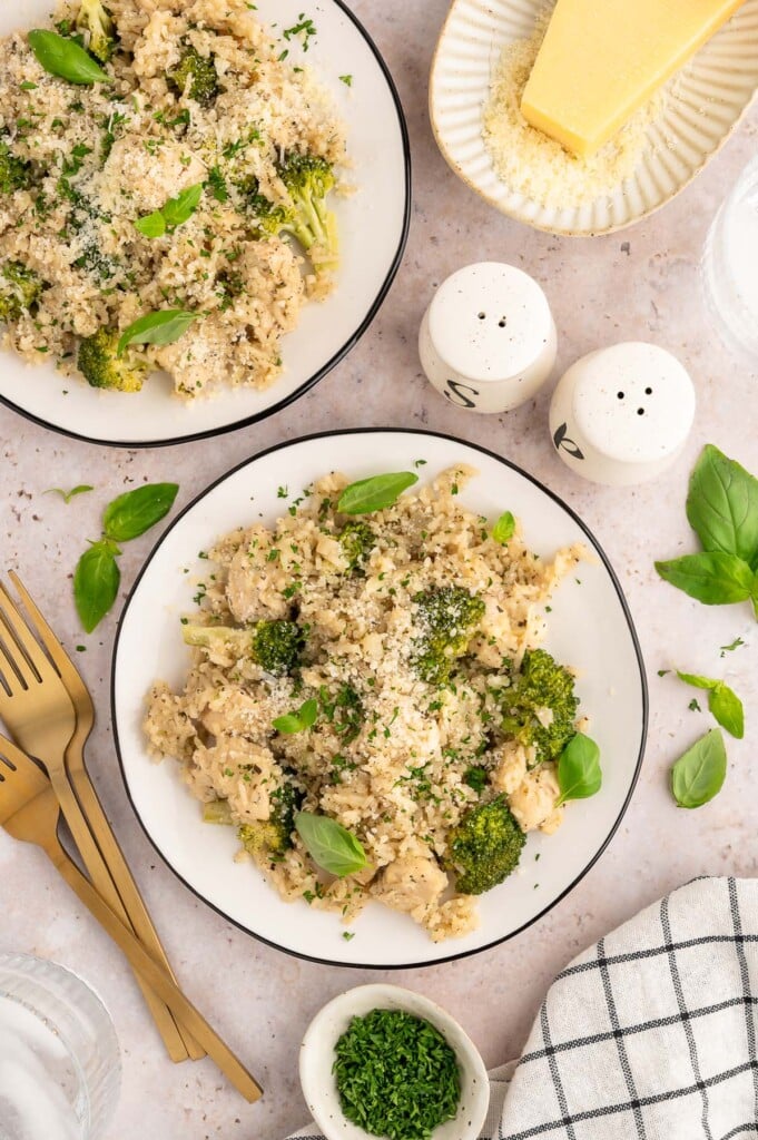 Chicken and Broccoli Rice on two plates with forks and salt and pepper on the side. 