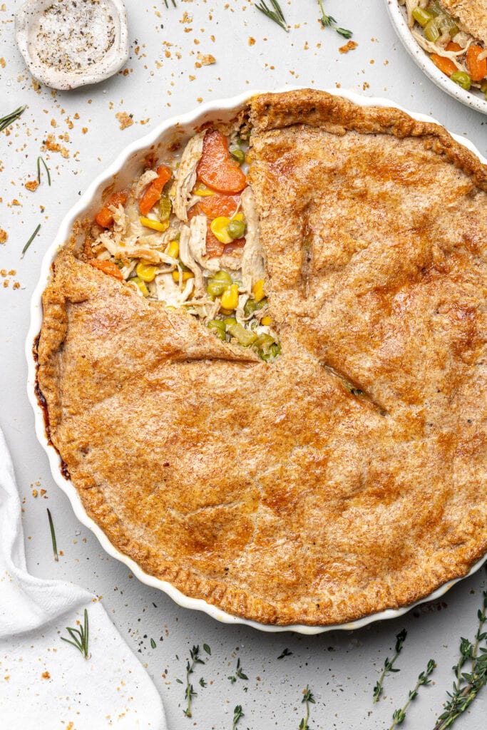 Healthy Chicken Pot Pie with a piece taken out of it on a grey background 