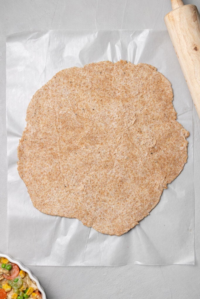 Healthy chicken pot pie crust rolled out on wax paper 