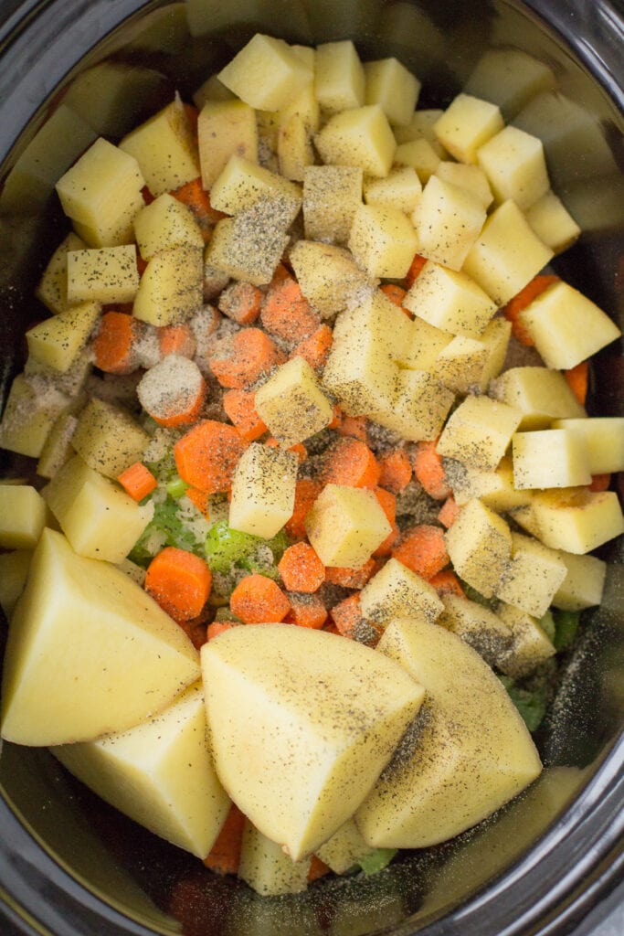 A close up of chicken pot pie soup in a crockpot before it cooks