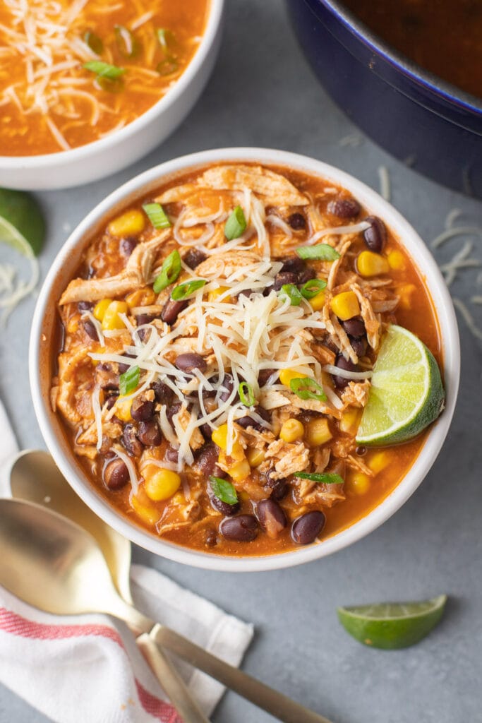 An overhead shot of chicken taco soup in a white bowl with another bowl to the side