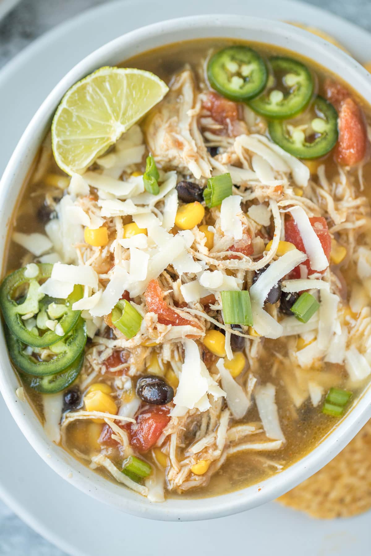 Chicken tortilla soup in a white bowl on a grey background