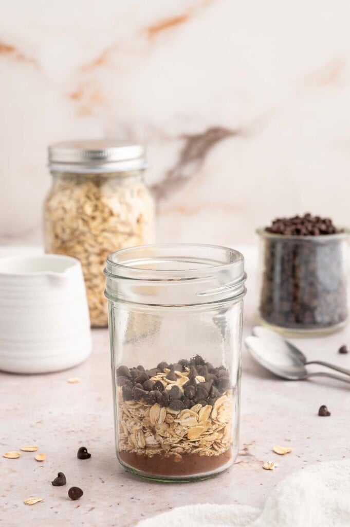 Cocoa powder, oats and mini chocolate chips layered in a mason jar.