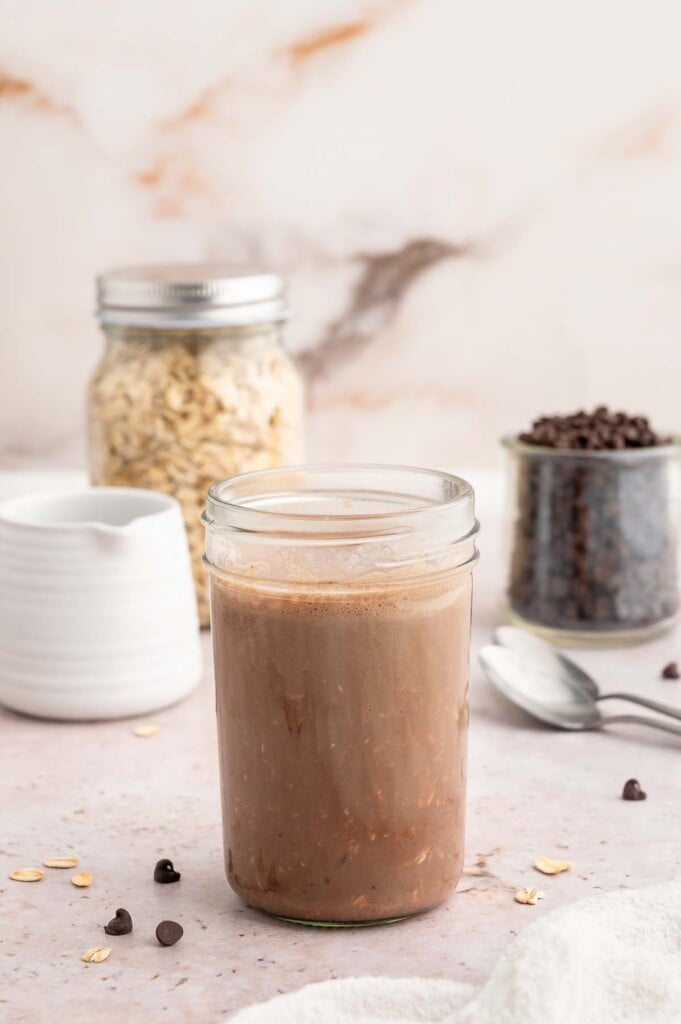 Chocolate overnight oats in a mason jar that have just been mixed together and not soaked yet. 