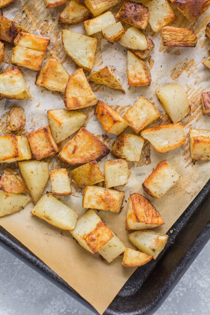 oven roasted potatoes recipe on a parchment lined baking sheet