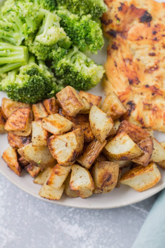 A plate of chicken + broccoli with crispy roasted potatoes