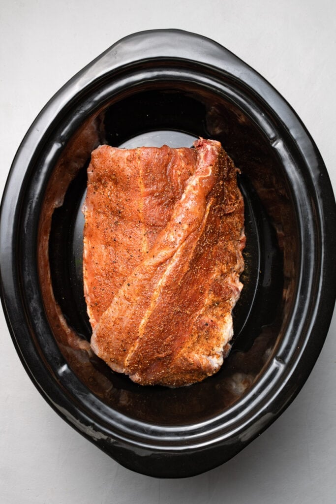 baby back ribs in a crock pot with water on bottom