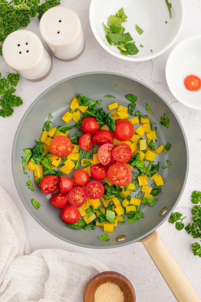 Bell peppers, spinach and cherry tomatoes in a pan. 