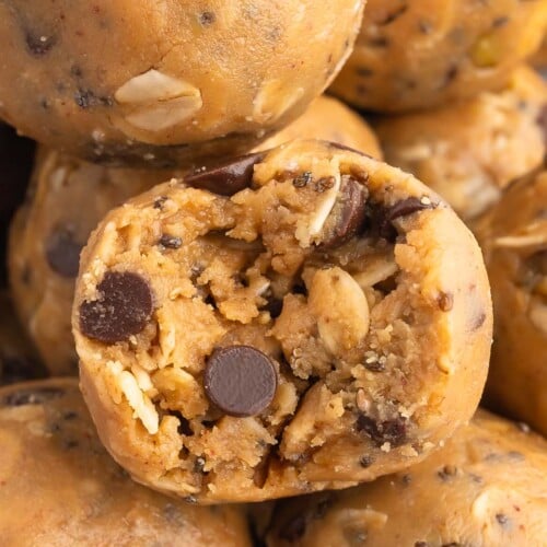a peanut butter oatmeal ball with a bite taken out of it surrounded by more energy balls