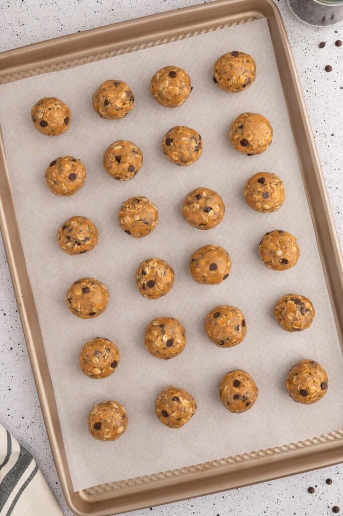 Peanut butter energy bites on a parchment lined baking sheet