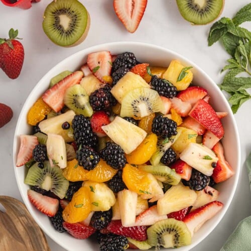 A large white bowl filled with a fruit salad.