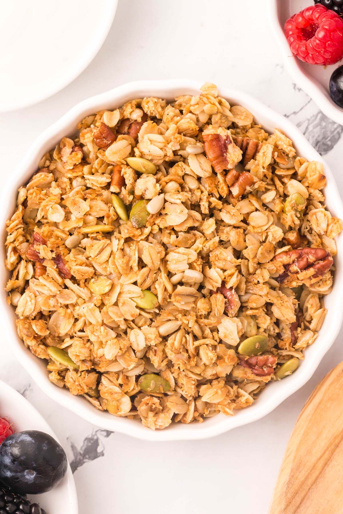 A white bowl of homemade granola on a white background