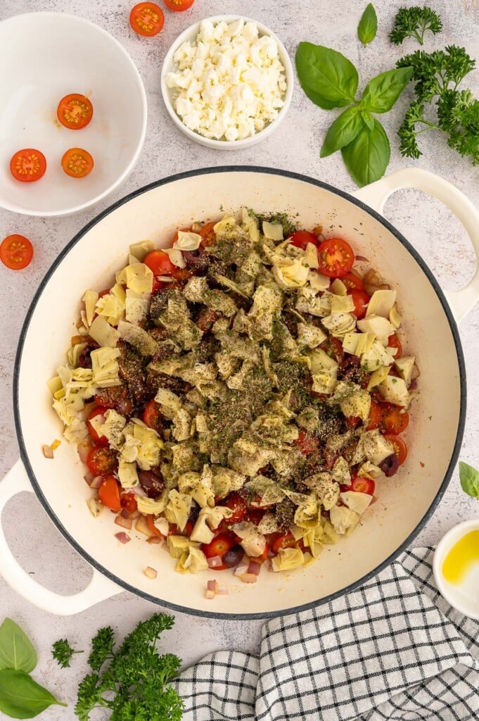 Ingredients for Greek style pasta in a dutch oven before being mixed together or spaghetti has been added.