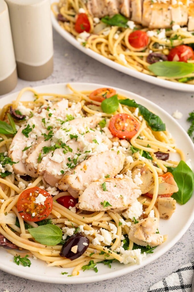 Greek Spaghetti topped with sliced chicken breast.