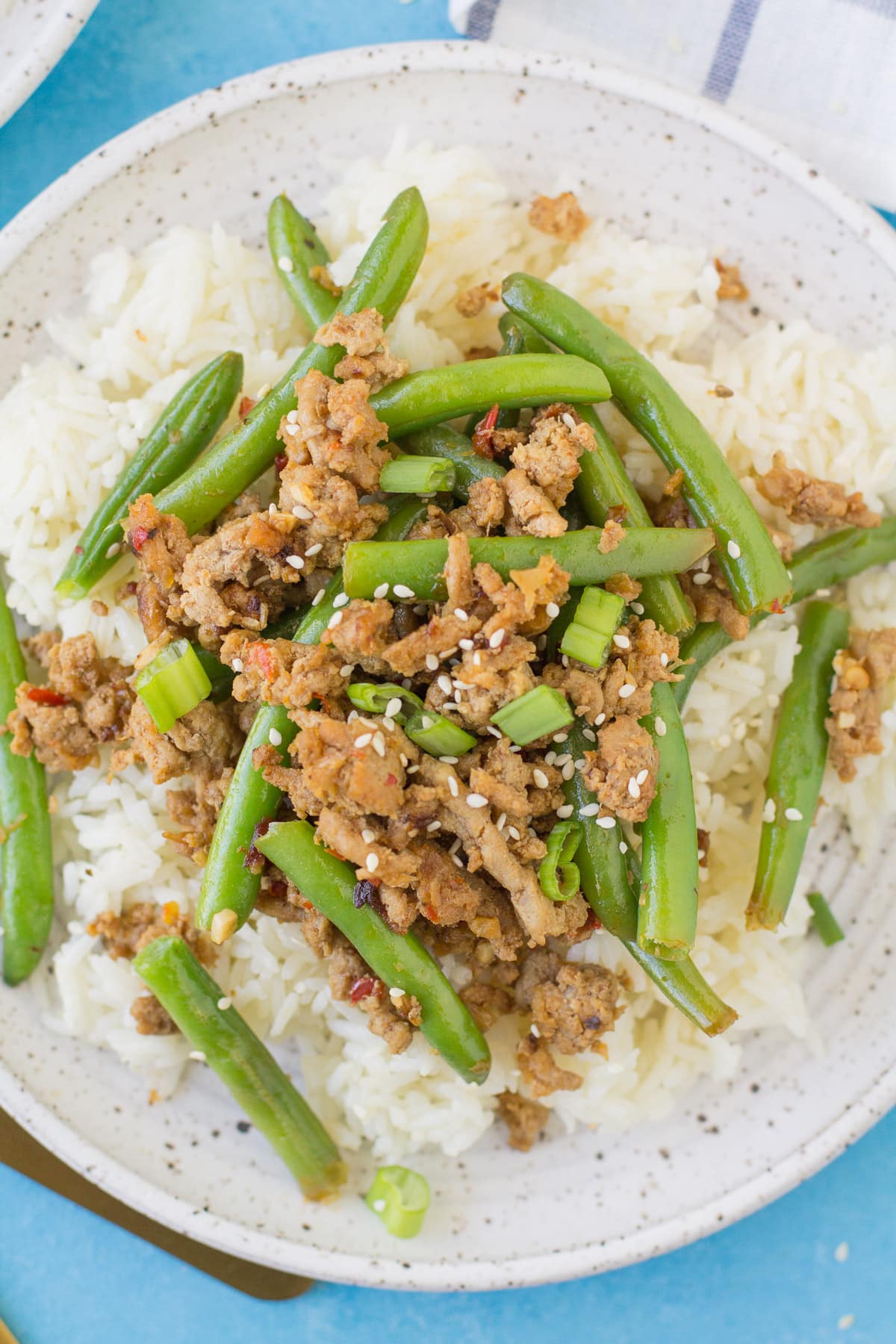 Spicy Ground Turkey Stir Fry on a white plate on a blue background