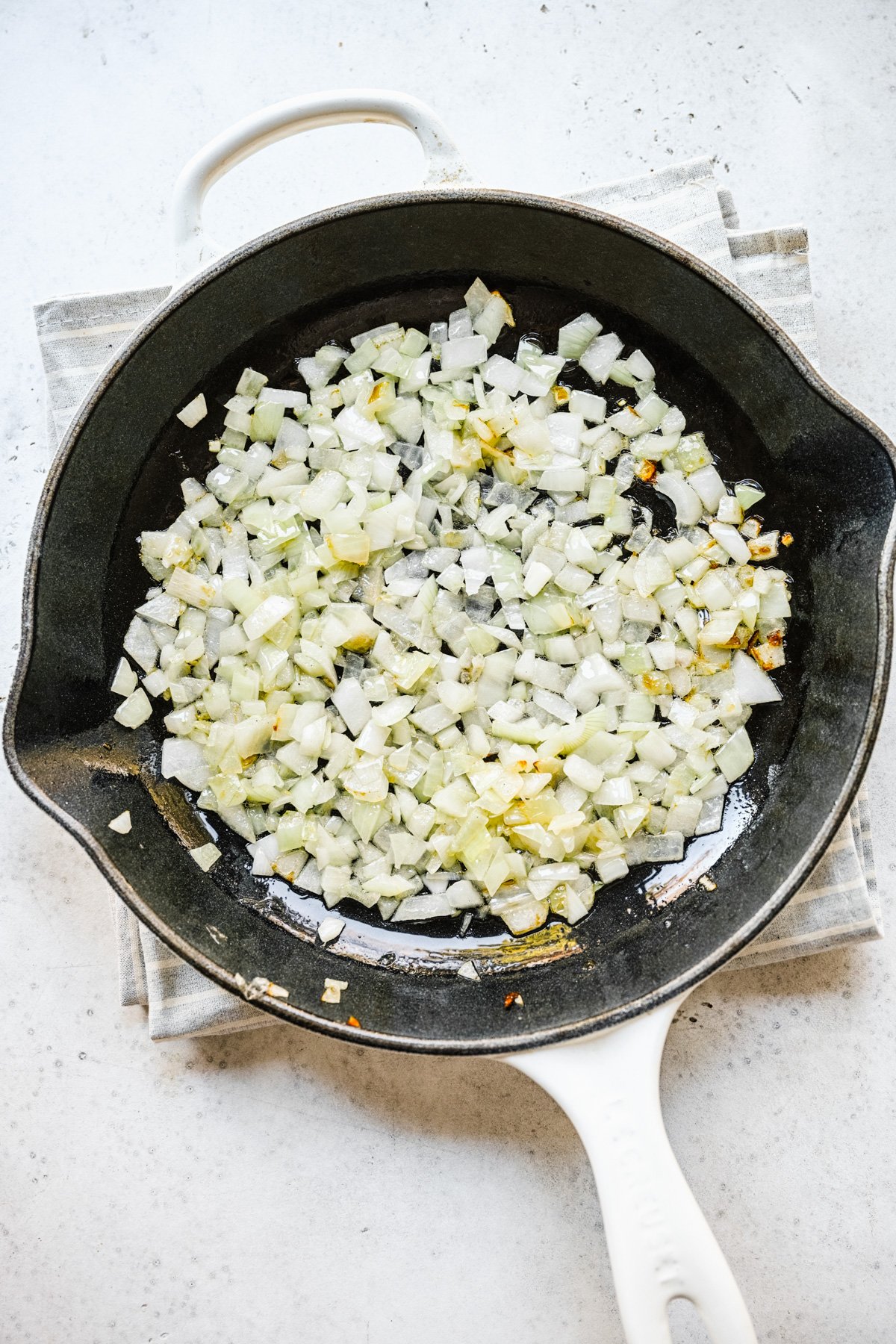 Onions cooking in a cast iron pan in butter for keto frittata