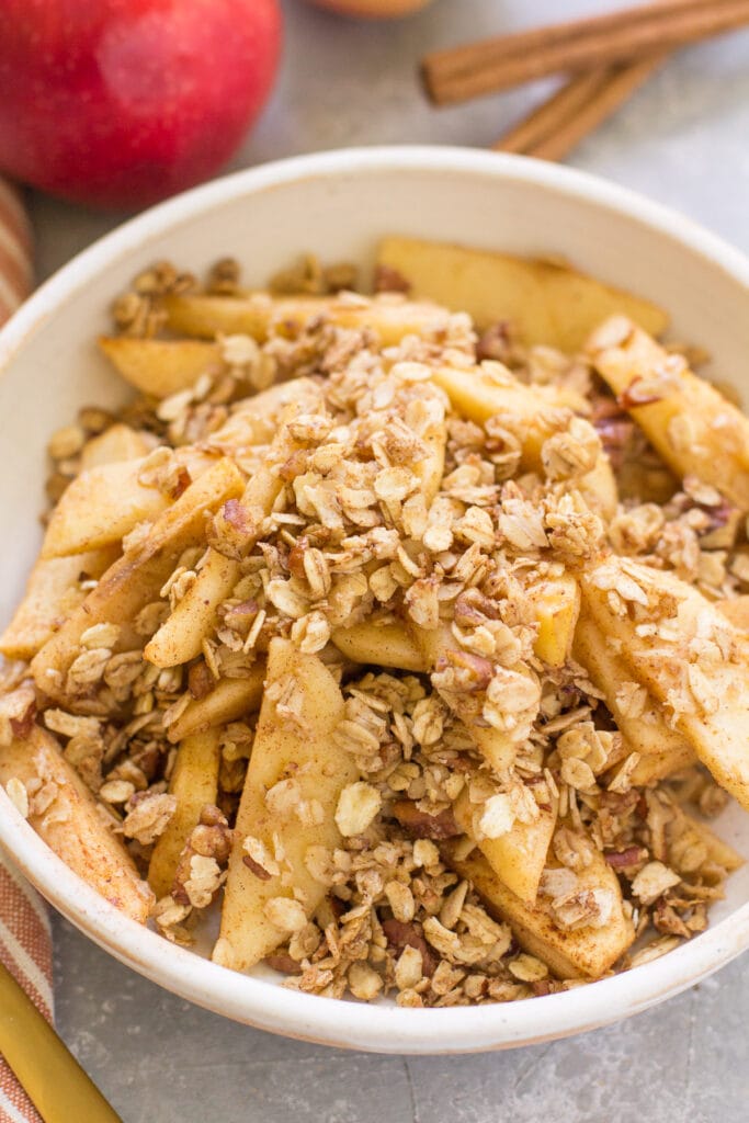 Healthy Apple Crisp in a white bowl on a grey background