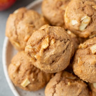 Healthy Apple Muffins on a white plate with a red and white linen in the back