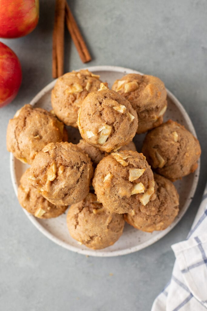 A plate of healthy apple muffins with a red and white striped linen in the background