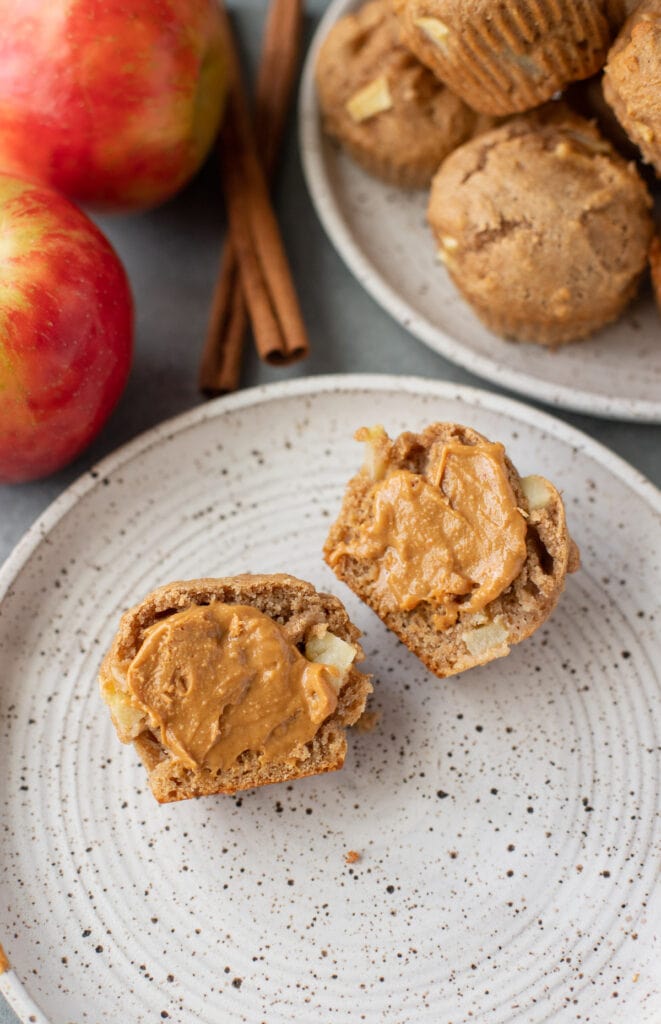 A close up of apple muffins recipe that have peanut butter slathered on them.