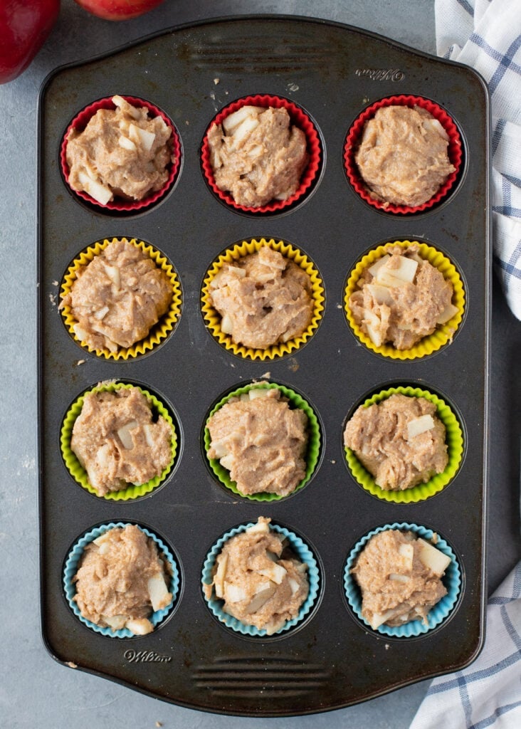 Apple muffins in a muffin tin before being baked