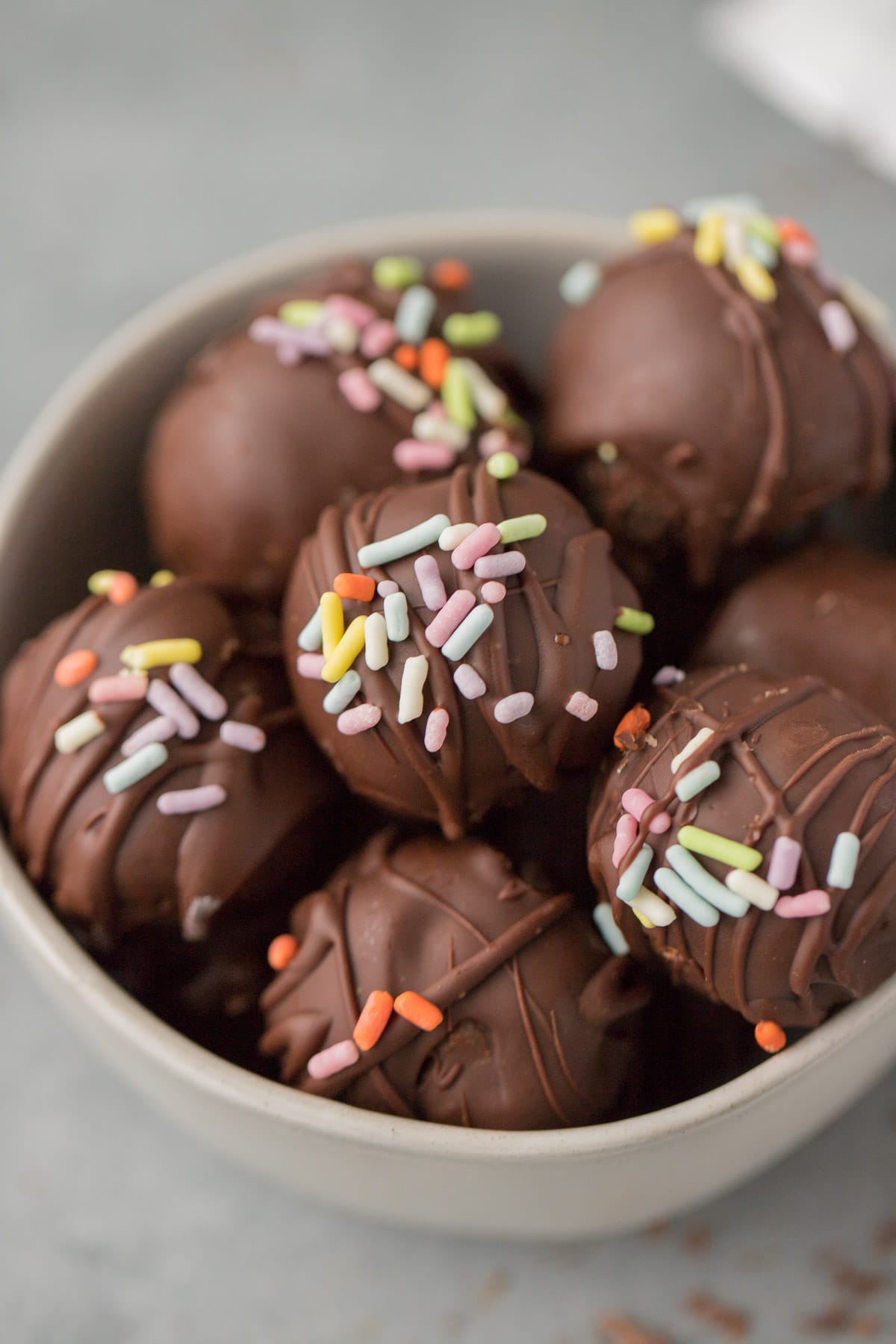 Healthy Brownie Truffles in a small white bowl on a grey background