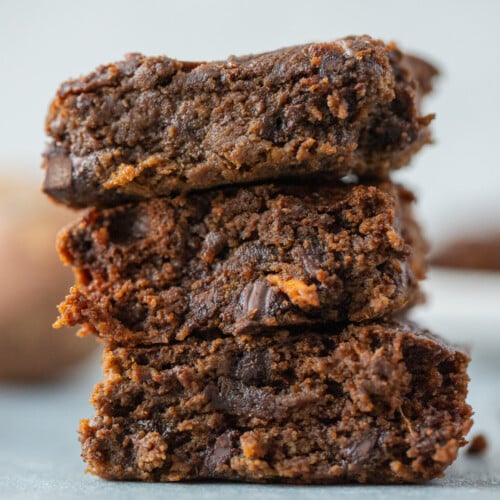 A stack of sweet potato brownies on a grey background