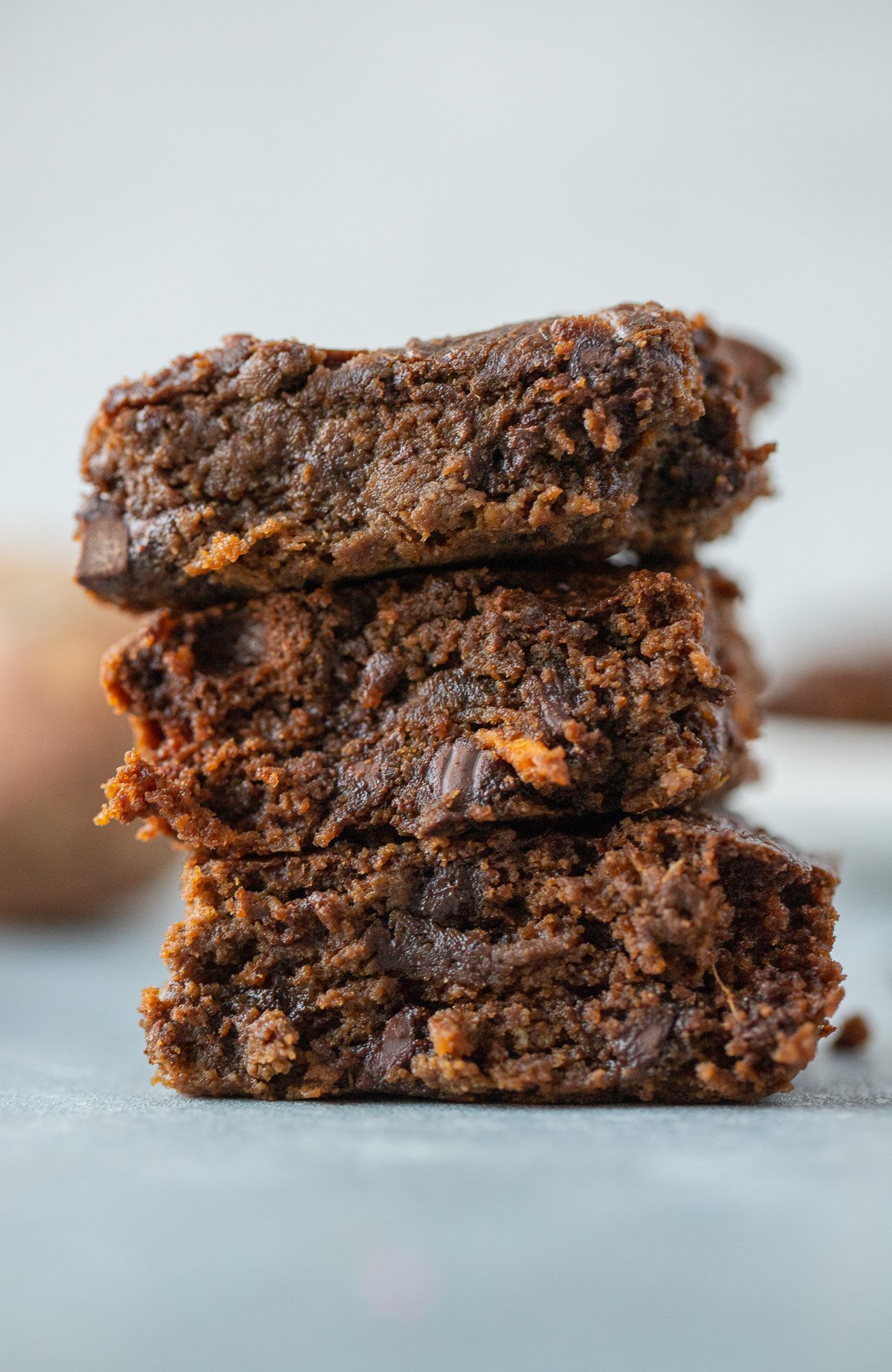 A stack of sweet potato brownies on a grey background