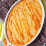 healthy buffalo chicken dip in a white dish fresh out of the oven.