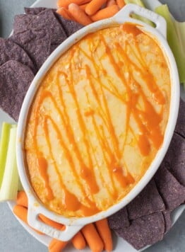 healthy buffalo chicken dip in a white dish fresh out of the oven.