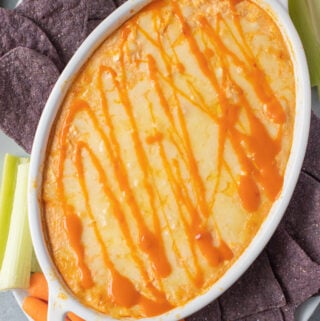 healthy buffalo chicken dip in a white dish fresh out of the oven.