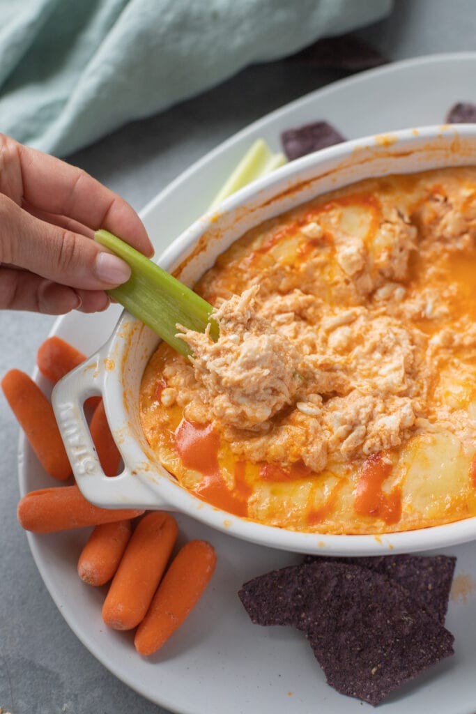Celery scooping up a bite of healthy chicken dip

